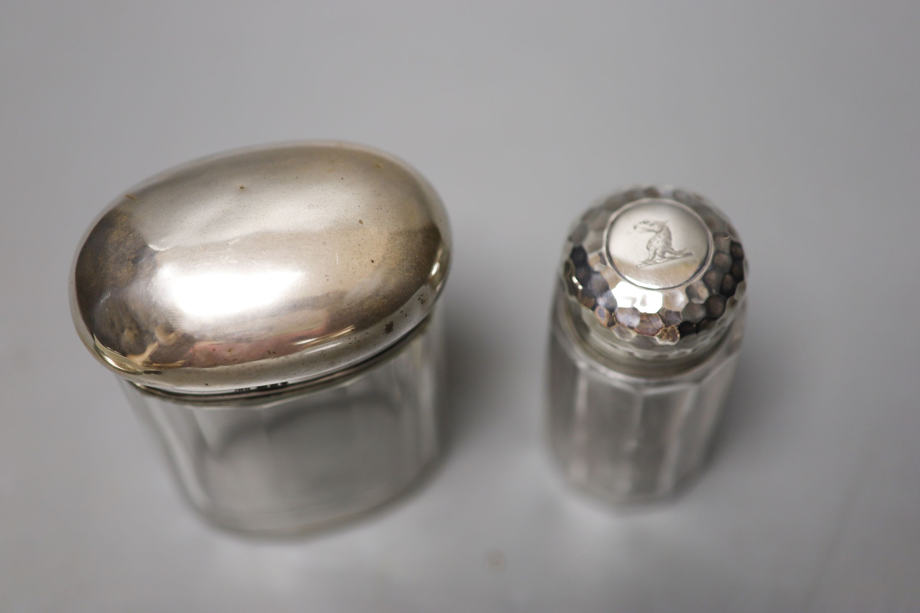 Six assorted silver mounted glass toilet jars, including a powder bowl and a Chinese white metal tot(a.f.).